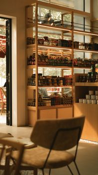 Warm café atmosphere featuring wooden shelves with various products in a modern setting.