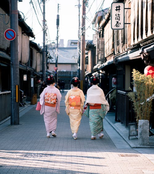 三個女人穿著傳統服飾在大街上行走