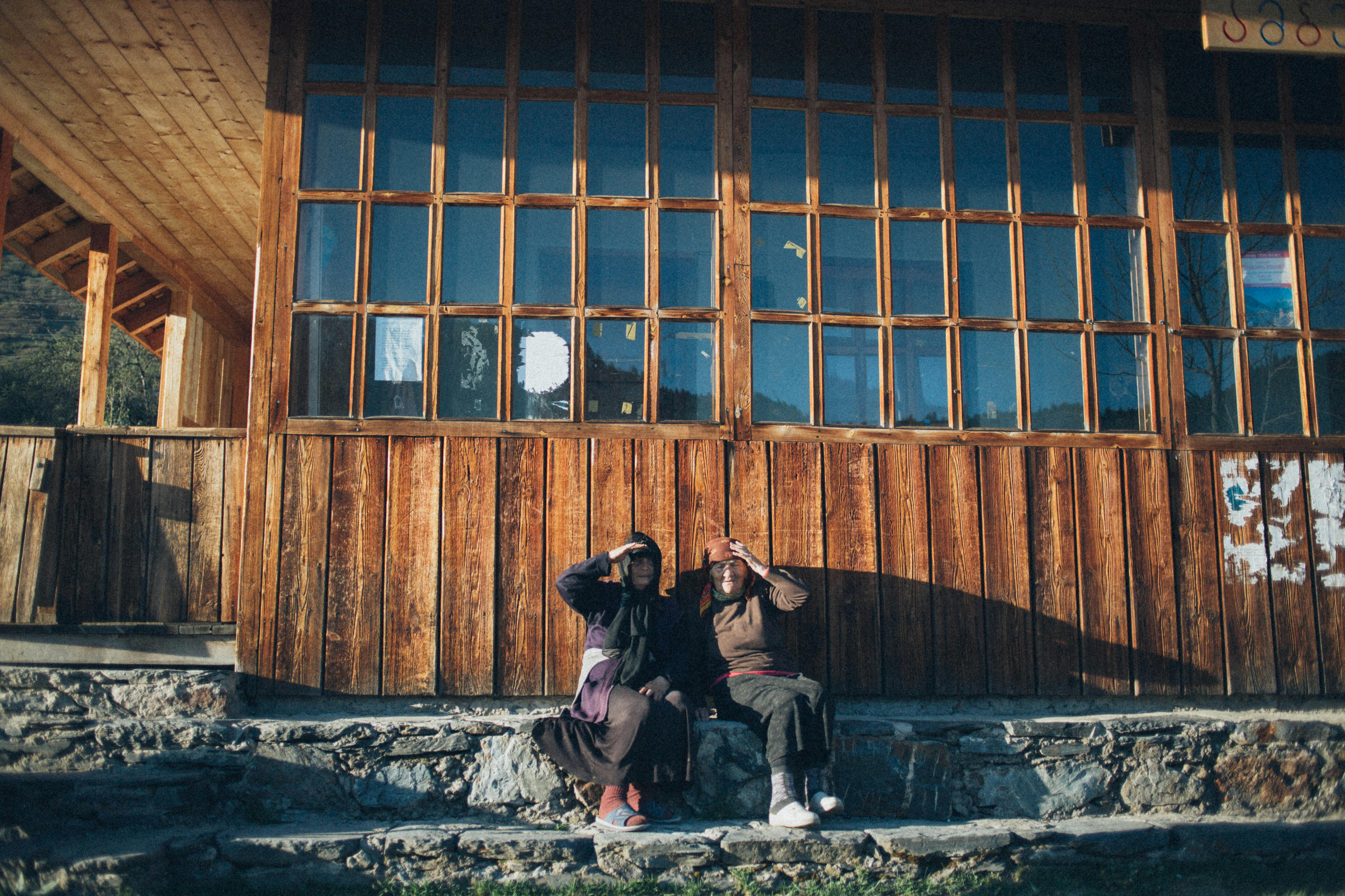 Two People Sitting On Grey Surface · Free Stock Photo