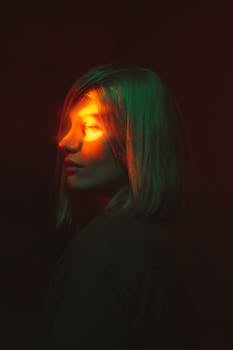 Moody portrait of a woman under dramatic colorful lighting effects.