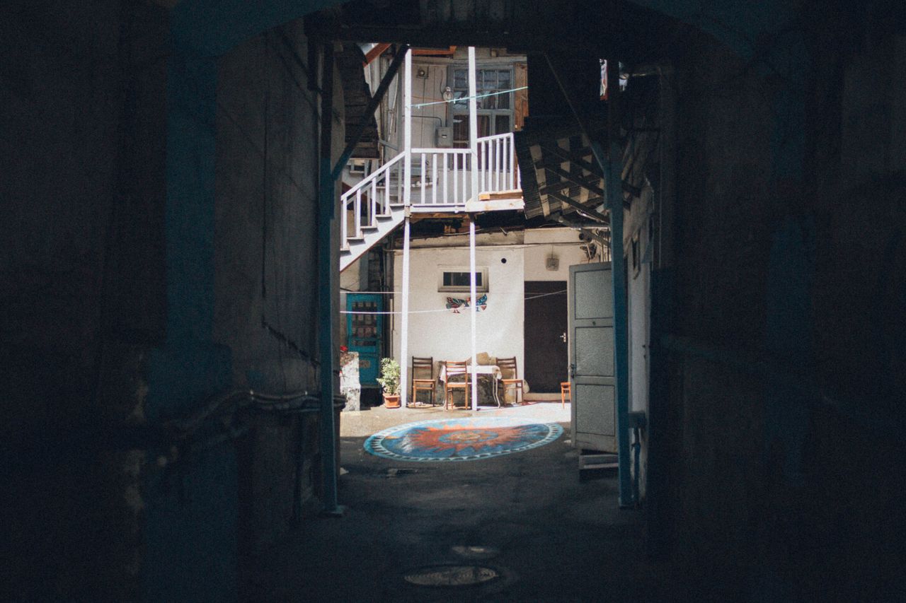 a quaint alleyway leading to a cozy outdoor seating area with artistic