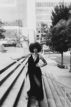 Black and white portrait of a woman in a flowing black dress on city steps, Atlanta.