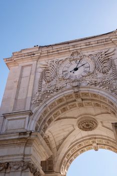 Low angle view of the iconic Arco da Rua Augusta with its ornate clock in Lisbon, Portugal.
