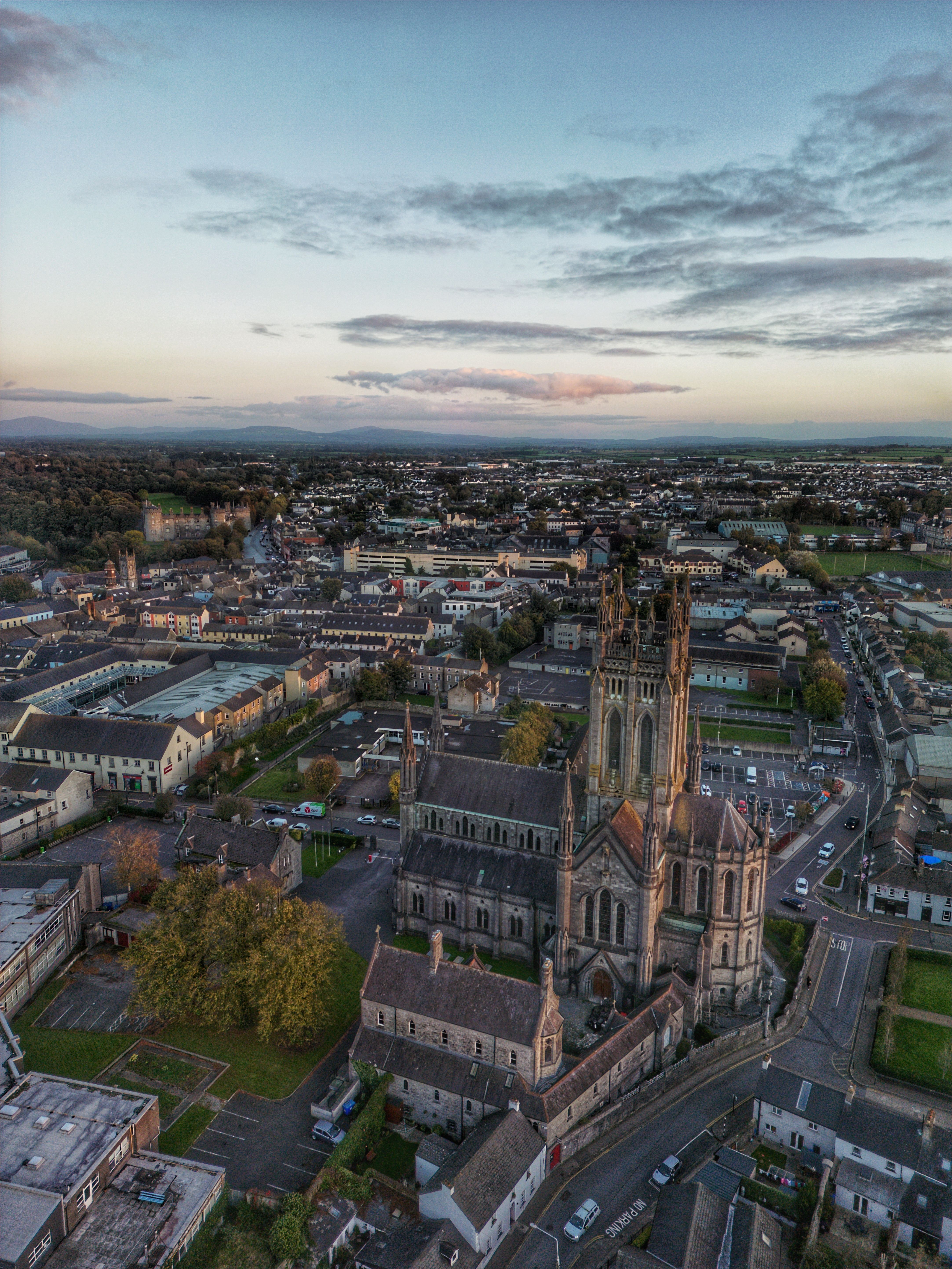 A stunning aerial shot of a Gothic Revival cathedral in Kilkenny, Ireland, showcasing the city's architecture at dusk.