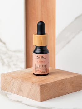 Close-up of a CBD oil bottle isolated on a wooden platform, ideal for healthcare and skincare uses.