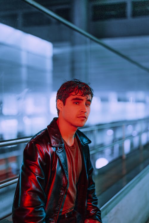 Red-lit Young Man in a Leather Jacket Waiting at the Airport
