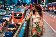 一位快乐的女子站在城市街头，展现了夜间充满活力的都市生活