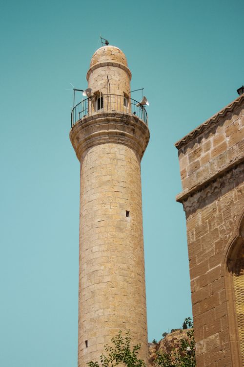 Free A beautifully preserved minaret rises against a clear blue sky symbolizing Islamic architecture. Stock Photo