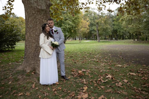 Newlyweds Together by Tree in Park