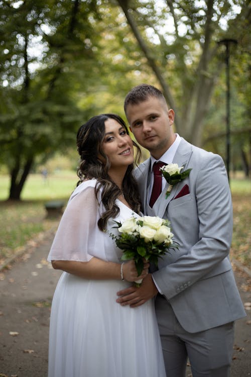 Portrait of Newlyweds with Flowers Bouquet