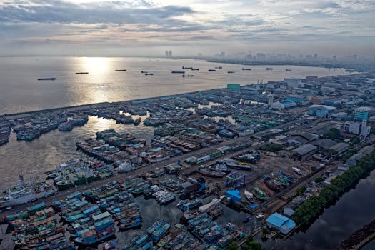 日出时，雅加达的港口展现在眼前，可以看到船只、工业建筑和城市景观