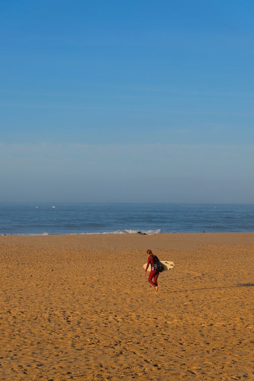 Tourist Carrying a Surfboard on the Beach