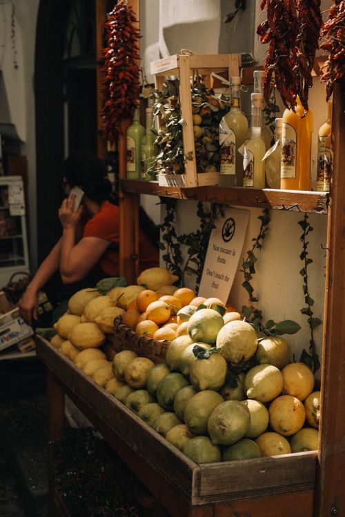 Free A vibrant display of lemons and limes at a market stall with decorative chili peppers. Stock Photo