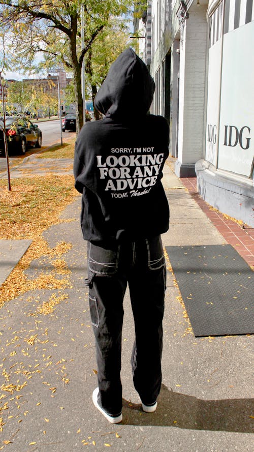 Man in Hoodie Standing on Sidewalk