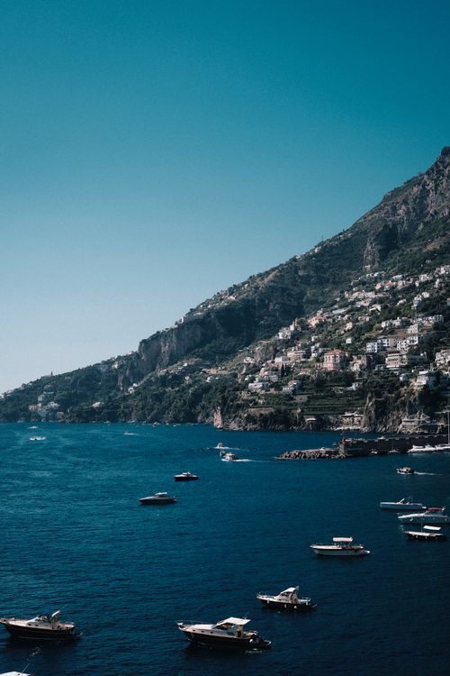 Free Stunning aerial view of boats near a coastal town on the picturesque Amalfi coastline. Stock Photo