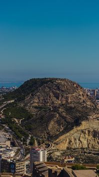 Aerial view of Alicante hill with urban landscape and sea in the background, perfect for travel and cityscapes.