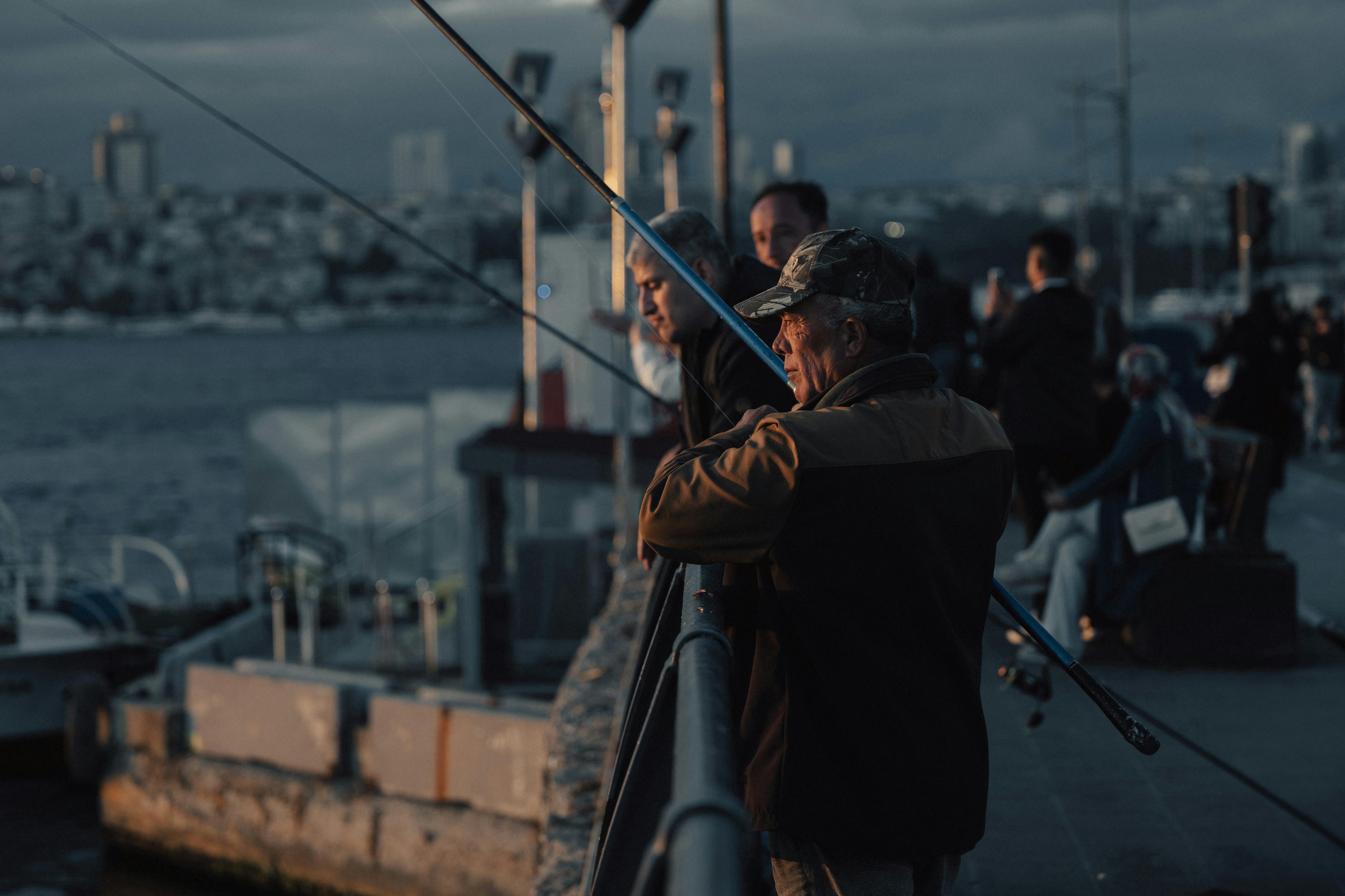 A group of fishermen casting lines at sunset in Istanbul, Türkiye.