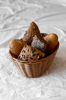 Rustic assorted bread rolls showcased in a classic wicker basket, ideal for breakfast or bakery themes.