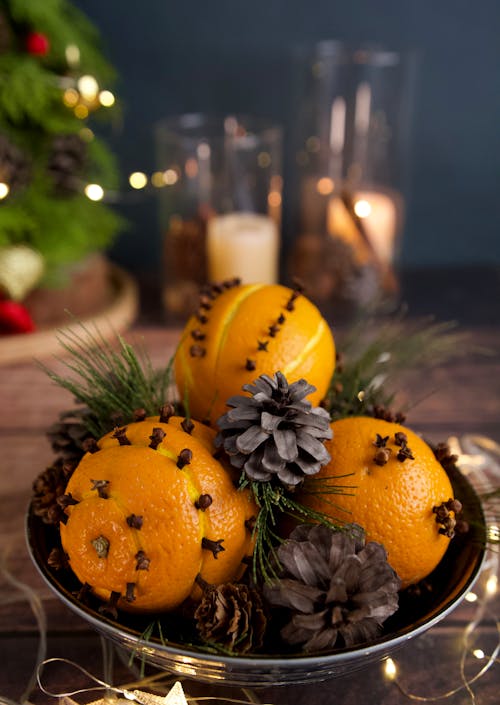 Clove-studded Oranges with Pine Cones in a Bowl