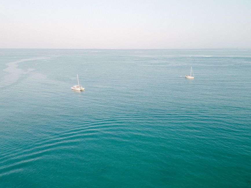 Spectacular Private Catamaran Adventure Cruise with Rope Swing and Water Slide Review 2026 - Drone capture of sailboats navigating the serene, expansive sea under clear skies.
