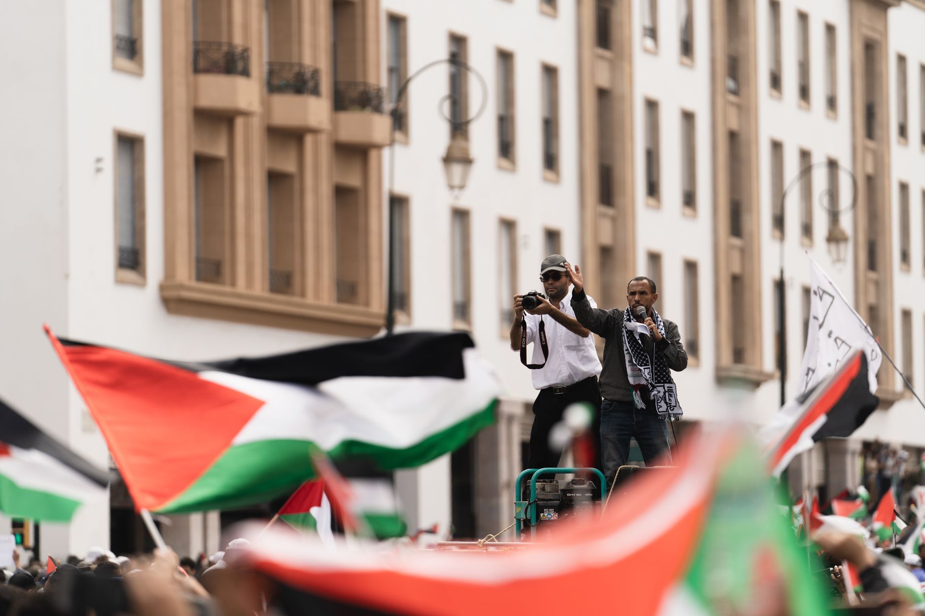 Large protest in Rabat with Palestinian flags and speakers, highlighting solidarity.