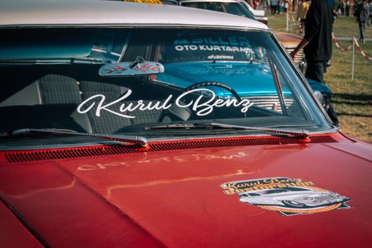 Close-up of classic car's front at outdoor vintage vehicle show.