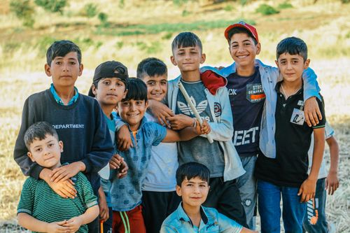 Free Smiling boys of different ages standing together in a rural setting during daytime. Stock Photo