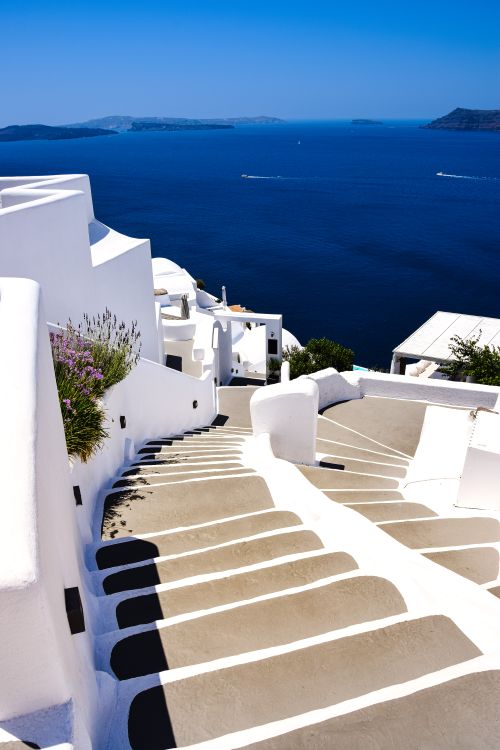 Free Explore the iconic whitewashed steps of Santorini with stunning views of the Aegean Sea. Perfect travel inspiration. Stock Photo
