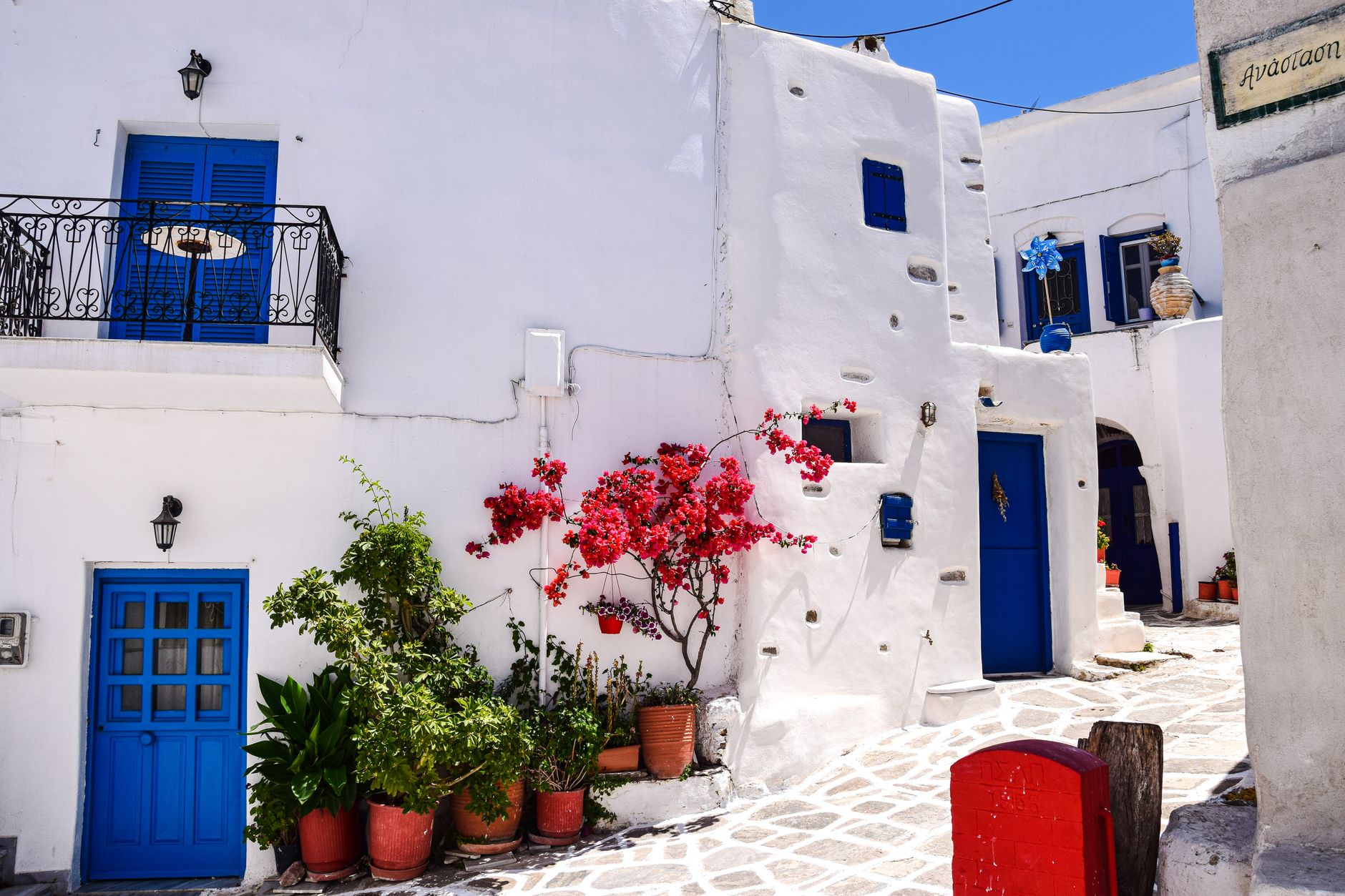 Picturesque Greek alleyway with whitewashed buildings and vibrant blue accents, perfect for travel inspiration.