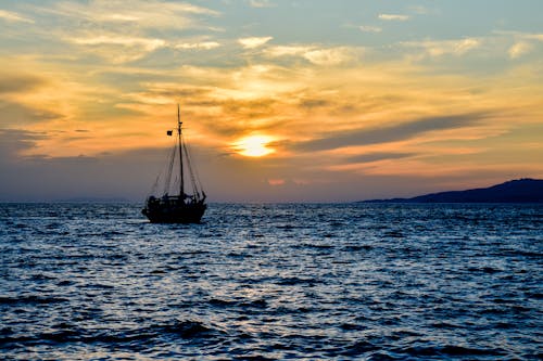 Ship Sailing on Sea at Sunset