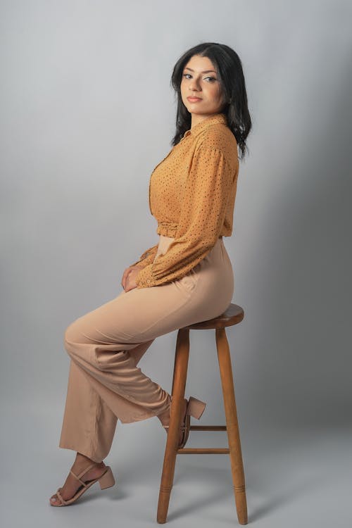 Foto profissional grátis de cabelo comprido, cadeira, camisa laranja