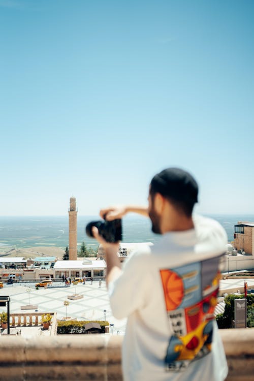 Photographer in Hat Taking Pictures in Town