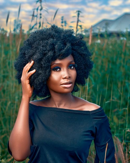 Free Elegant portrait of a woman with curly hair in a Nigerian field. Stock Photo