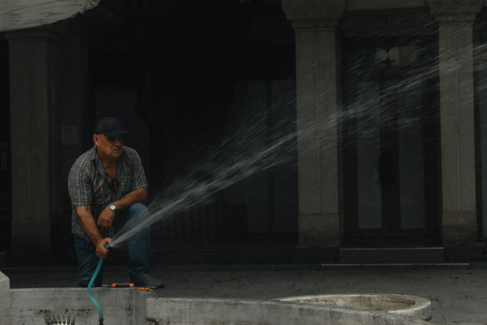 Man Watering with Hose