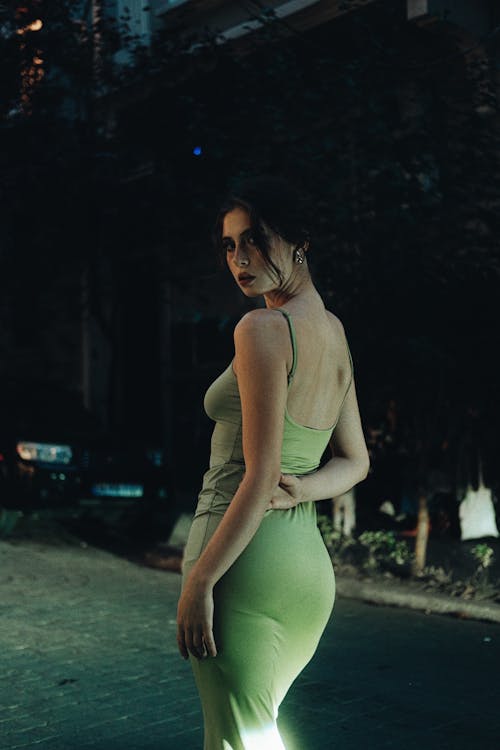 Model in Green Dress on Street at Night