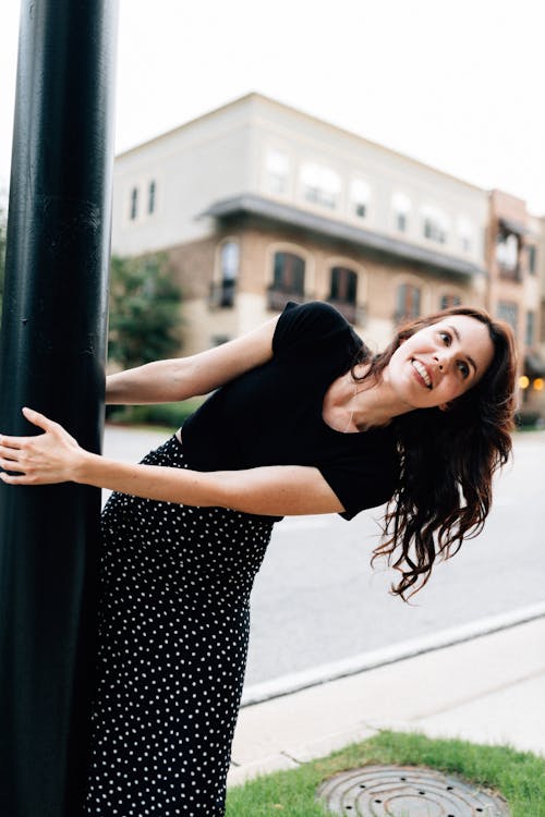 Smiling Woman Leaning on Pole