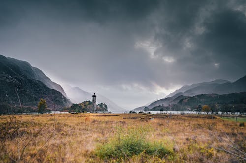 Rain Clouds over Grassland with Lake and Hills behind