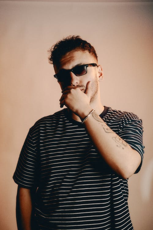 Young Man Posing in Striped T-Shirt and Sunglasses