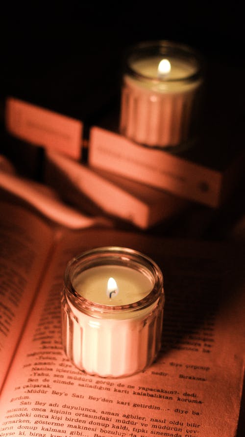 Burning Candle Standing on an Open Book