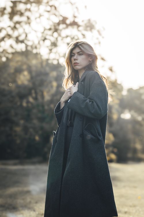 Free Elegant woman posing in park wearing a coat during fall season. Stock Photo