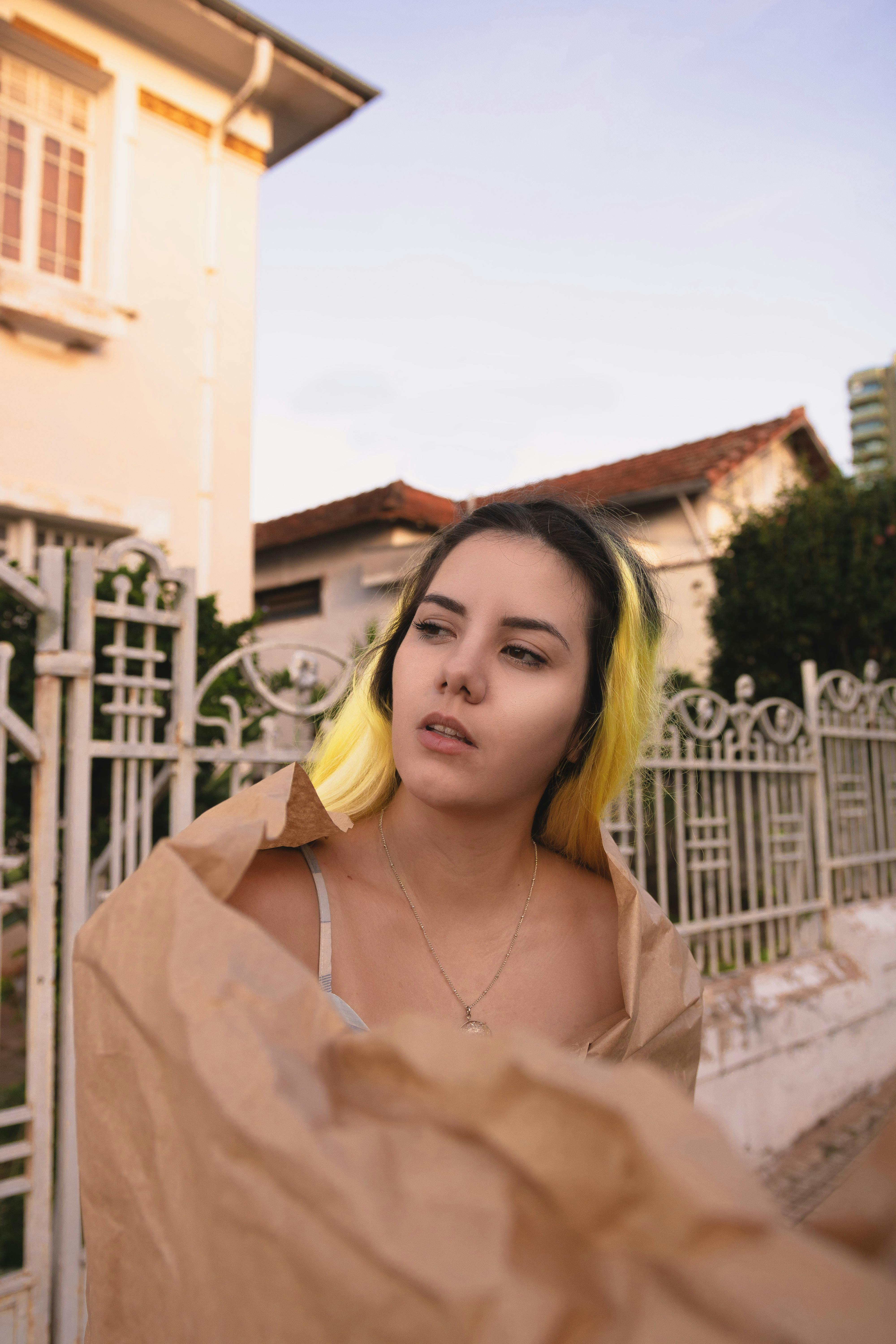 黑发女子裹着牛皮纸，背景是城市户外