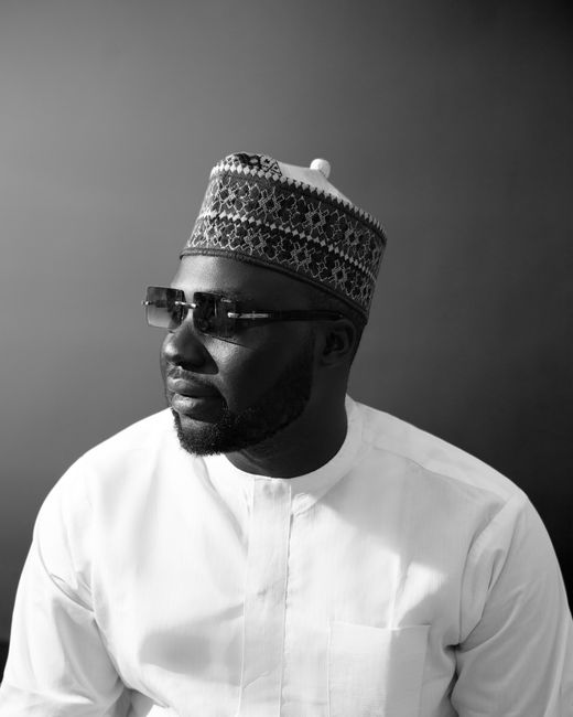 Stylish black and white portrait of a man in a traditional hat and glasses. Captured in Abuja, Nigeria.