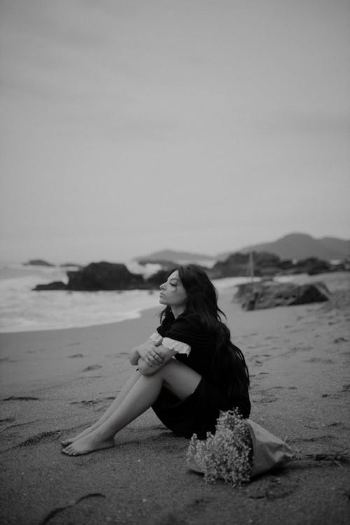 Woman Sitting on a Beach in Black and White