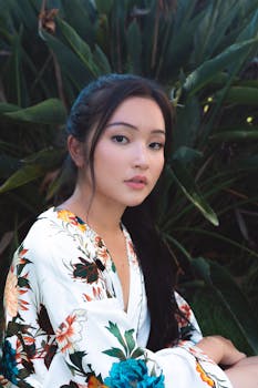 一位年轻女子身着花卉服装，在郁郁葱葱的绿色植物映衬下，显得格外优雅