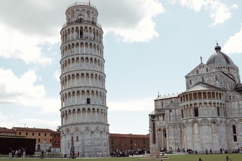 Free Leaning Tower of Pisa and the Cathedral under a bright sky, ideal for travel or architecture themes. Stock Photo