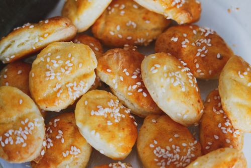 Free Freshly baked sesame seed buns, golden and homemade, on a white plate. Stock Photo