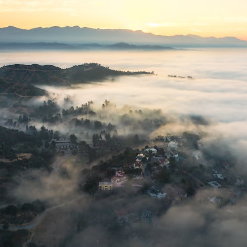 Aerial view of foggy valley with houses and trees