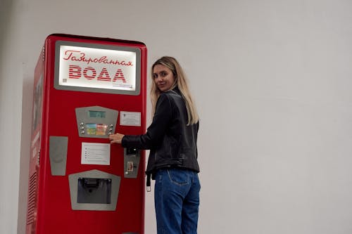 Woman Standing beside a Vintage Machine 