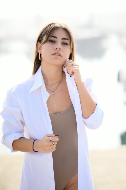 Woman Wearing a Swimming Costume and a White Shirt Posing Outside 