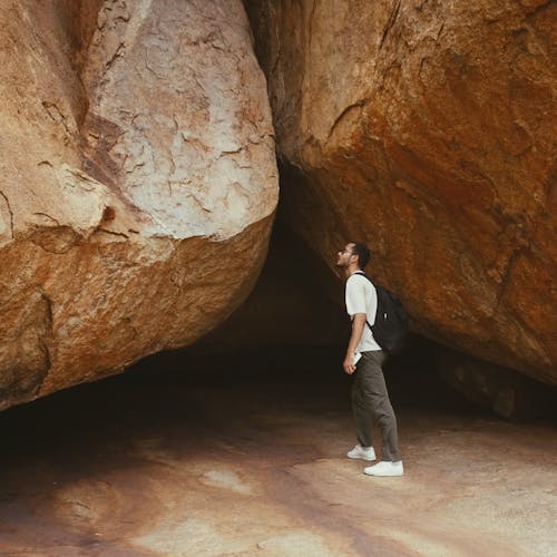Man with Backpack Looking at Boulders